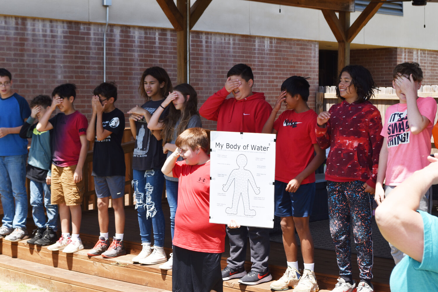 Middle schoolers demonstrate the importance of water to the body while acting out a song.